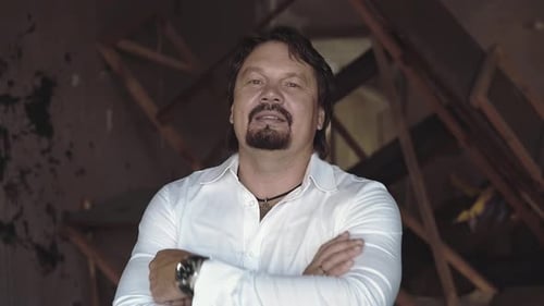 Retrato de um jovem brutal com uma barba que ri de perto