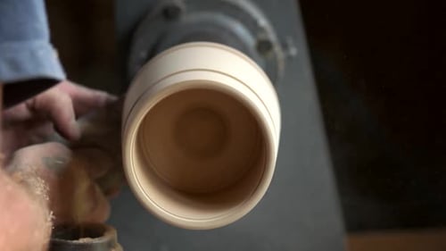 Woodworker Sanding Wooden Bowl on Spinning Lathe