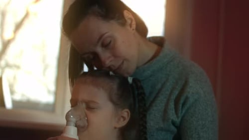 Child Receives Nebulizer Treatment with Mother's Support