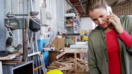 Woman Talking on Phone in Workshop