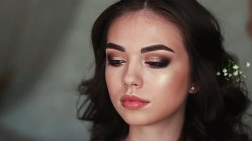 Maskenbildnerin trägt Puder auf das Gesicht des Models auf