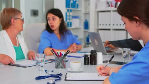 Medical Team Discussing X-Ray in Hospital Boardroom