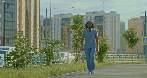 Young Man Walks Along the Sidewalks of the Street a Walk in the City