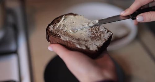 Woman Spreads Cream Cheese on Slice of Bread