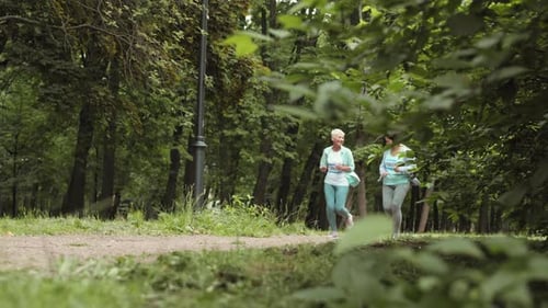 Two Attractive Aged Women Jogging in Park