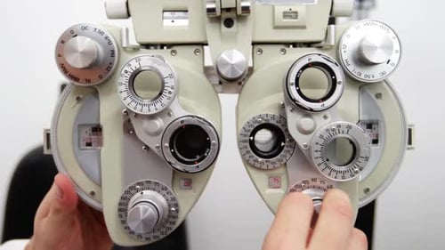 Optometrist Adjusting Phoropter for Eye Examination