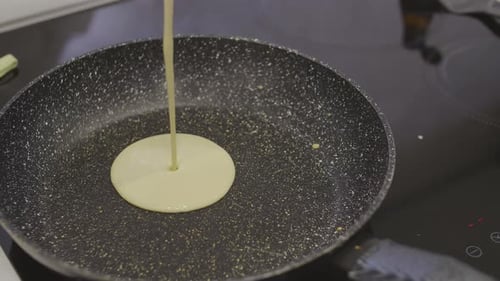 Cooking pancakes for breakfast at home in kitchen