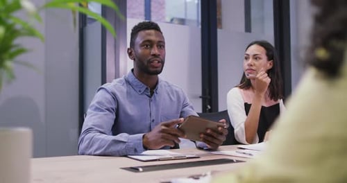 Diverse group of business people working together, discussing work in modern office
