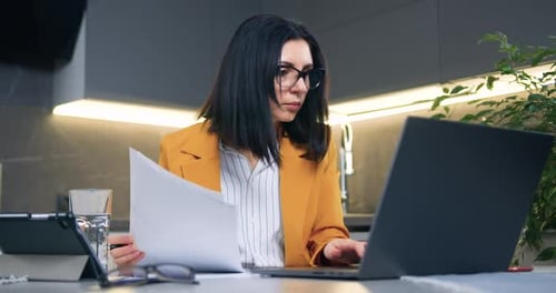 Woman Works on Laptop at Kitchen Desk