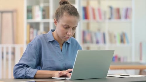 Professional African Woman Working on Laptop in Library