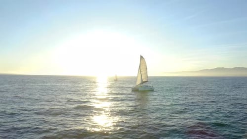 Aerial view. sailboat floats in water by beautiful sunset.