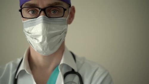 Masked Medical Professional Looks into the Camera