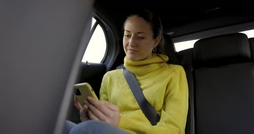 Woman Using Phone in Car Back Seat