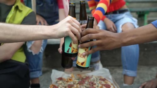 Friends Toasting with Beer While Eating Pizza