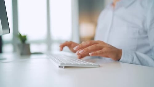 Hands Typing on Keyboard in Modern Office