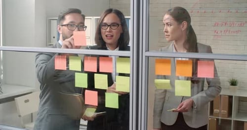 Team Collaborates Using Sticky Notes in Modern Workplace
