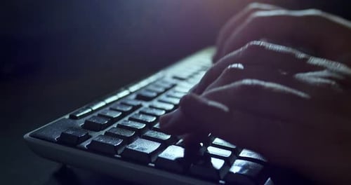 Nachts auf der Tastatur tippen. Nahaufnahme der dunklen Hintergrundbeleuchtung