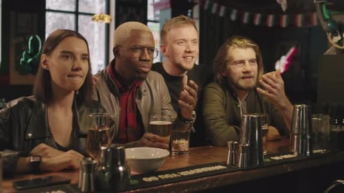 Friends Watching Sports Game At Bar
