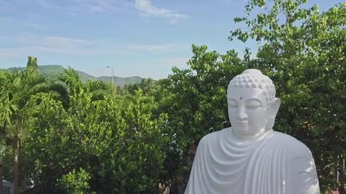 Drone Flies Close To Buddha Statue Among Tropical Plants