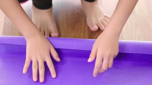 Front view of B roll shot of woman roll out yoga mat for preparation