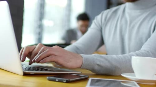 Redhead Businessman Typing on Laptop at Cafe Table