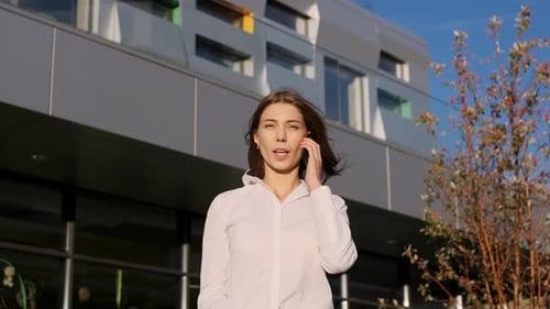Businesswoman Using Cell Phone Outside Modern Building
