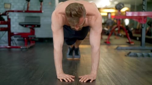 Hübscher männlicher Athlet macht einen vollen Diamant-Push-up
