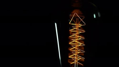 Vintage Light Bulb Incandescent Filament Close Up Macro with Black Background
