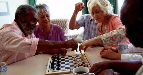 Active mixed-race senior people playing chess game in the nursing home 4k
