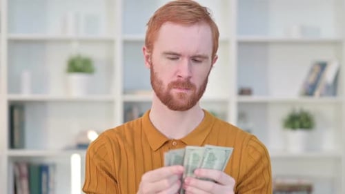 Red-Haired Man Counting Cash Money Indoors