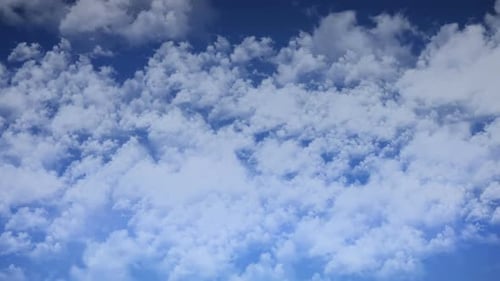Fluffy White Clouds Moving Across Blue Sky
