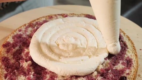 Cream Piping onto a Pink Layer Cake