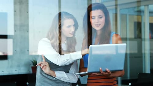 Business Women Collaborate on Laptop in Modern Office