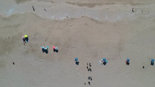 Aerial Timelapse of beach umbrellas and waves