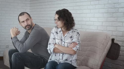 Upset Couple Sitting on Couch After Fight
