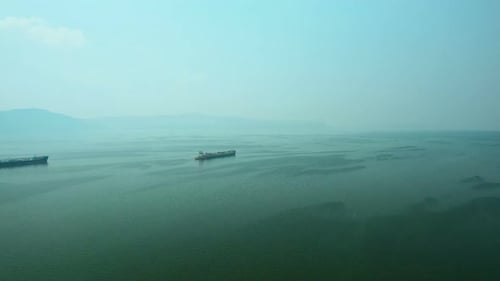 Luftaufnahme, Frachtkähne, die ins Meer segeln. Frachtschiffe segeln über das endlose Meer.