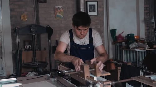 Man Assembling Wooden Structure in Workshop