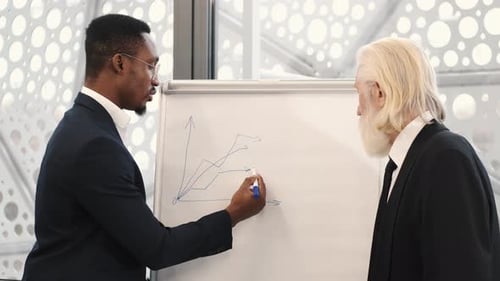 Architect and Engineer Looking at Scketch Blueprint at Office and Discussing Project