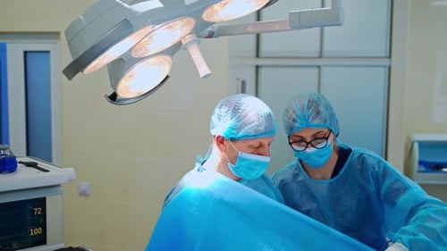 Surgeon and a nurse doing an operation in clinic