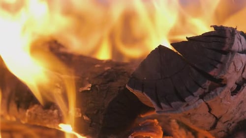 Close Up of Brightly Burning Wooden Logs with Yellow Hot Flames of Fire at Night