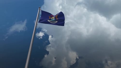 Michigan State Flag Waving Against Cloudy Blue Sky