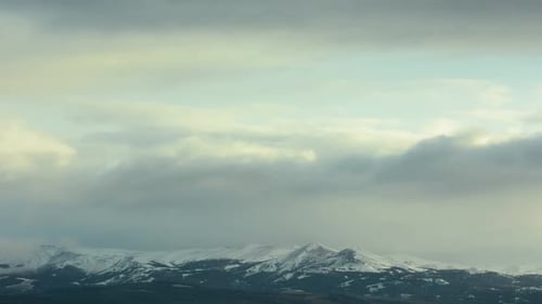 Snowy Mountains Under Cloudy Winter Sky