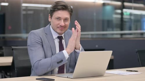 Man in Suit Works at Laptop, Clapping