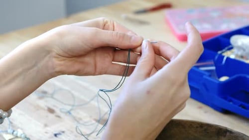 Handbespannende Perlen für Frauen auf den Faden, Herstellung von Schmuck in der Werkstatt.