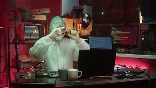Technician in Protective Suit Working in Dark Lab