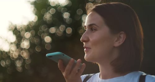 Young Beautiful Smiling Woman Talks on Mobile Telephone City Street Cars Taxi Audio Message Voice