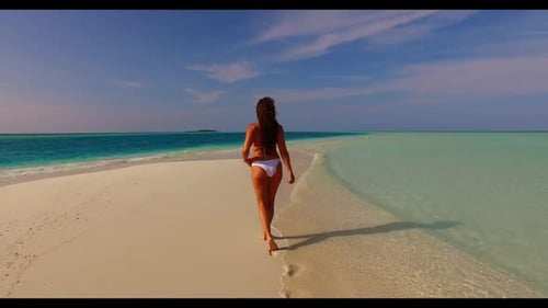 One girl relaxing on paradise resort beach vacation by shallow water with white sandy background of