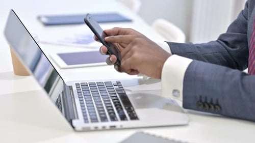 Close Up of Professional African Man Using Smartphone in Office