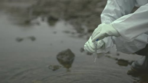 Close Up of Ecologist Taking Sample of Water in Polluted Area