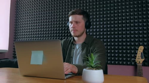 Sound Designer Working on Notebook in Music Studio